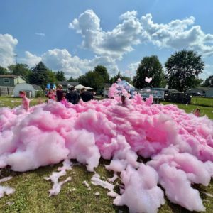 a green grassy field covered in pink foam