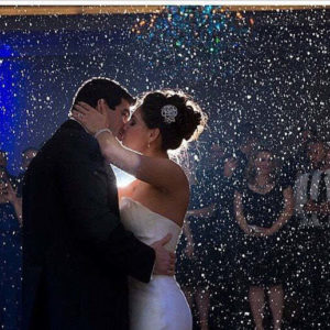 a wedding party with a snow machine in the background. Snowy wedding exit